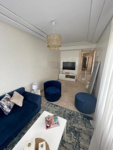 sala de estar con sofá azul y sillas azules en Petit appartement 68m2 quartier Bourgogne en Casablanca