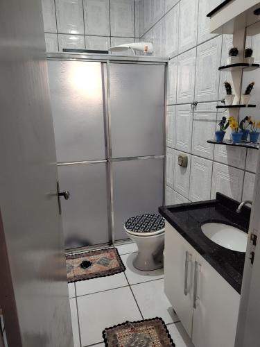 y baño con ducha, lavabo y aseo. en CASA PRÓXIMO A ENSEADA com 3 quartos, churrasqueira e ar-condicionado, en São Francisco do Sul