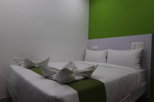 a white bed with a stuffed animal sitting on it at Athulya Stays in Bengaluru