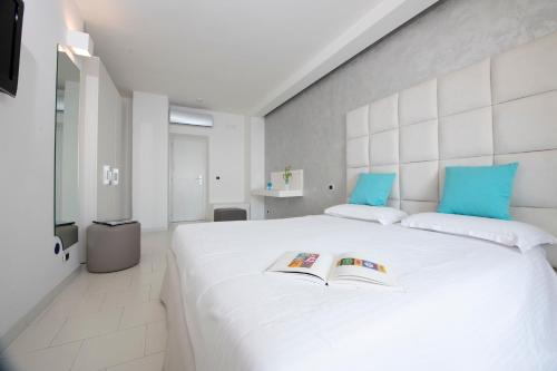 a bedroom with a large white bed with two books on it at Hotel Villa Felice Relais in Amalfi