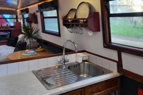 cocina con lavabo de acero inoxidable y espejo en Comfy Canal Boat in London Centre Family & Friends en Londres