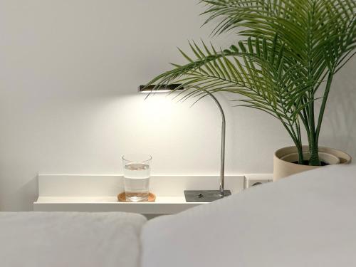un vaso de agua en una mesa blanca junto a una planta en Schöne Ferienwohnung im Zentrum mit Self Check-In und Free Wifi, en Essen