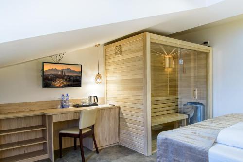 a hotel room with a desk and a bed at Penzión Berg in Kežmarok