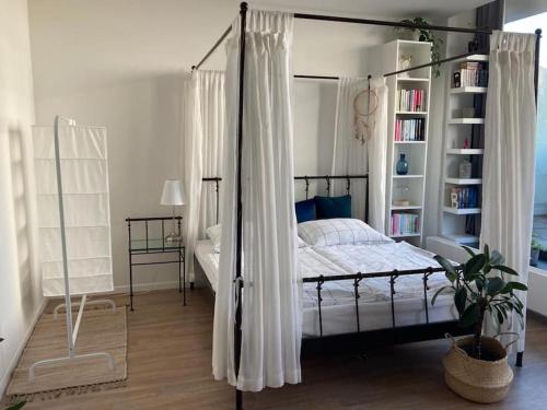 a bedroom with a canopy bed and a book shelf at Útulný a moderný ateliér s terasou in Nivy