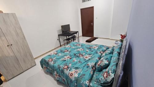a bedroom with a bed and a desk with a computer at Baith al jannah in Abu Dhabi