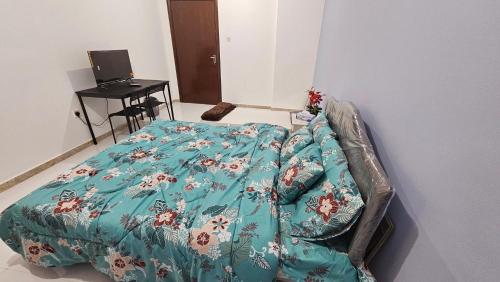 a bed with a blue comforter in a room at Baith al jannah in Abu Dhabi