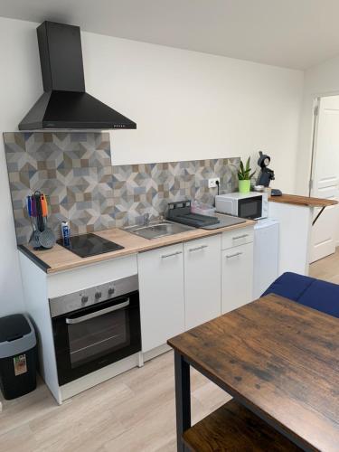 a kitchen with white appliances and a wooden table at My Sweet Home in Varennes-le-Grand