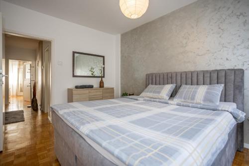 a bedroom with a bed with a blue and white comforter at Apartment Sara in Belgrade