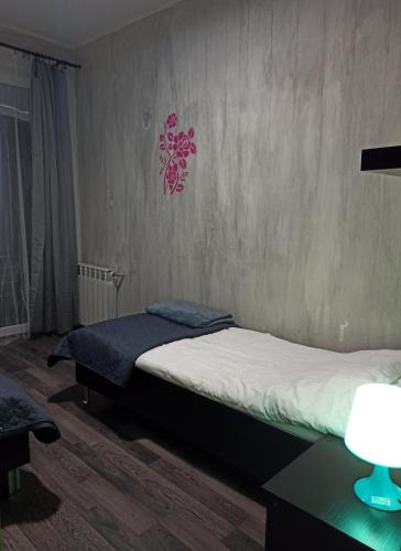 a bedroom with two beds and a table with a lamp at Apartaments Gory in Niedzica Zamek