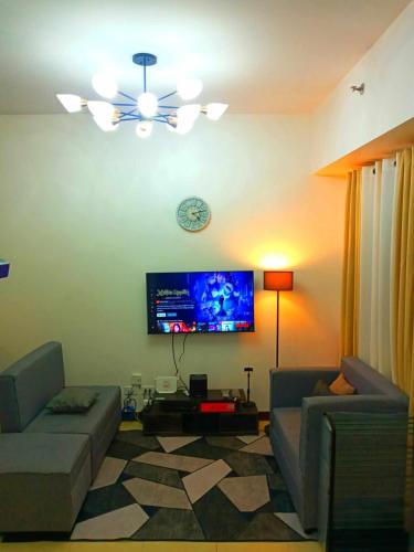 a living room with a couch and a flat screen tv at Traveler Residence by Celandine in Manila
