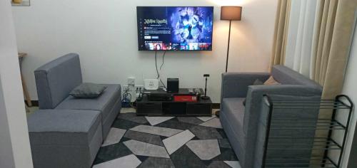 a living room with two couches and a flat screen tv at Traveler Residence by Celandine in Manila