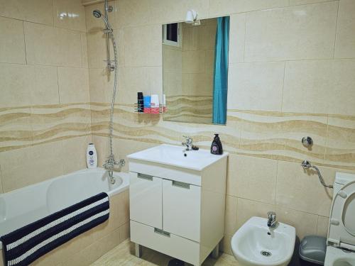 W łazience znajduje się umywalka, toaleta i lustro. w obiekcie Knowing Home 110sqm w mieście Parede