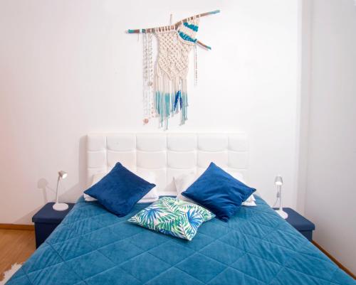 uma cama azul com duas almofadas azuis em The Terrace em Ponta Delgada