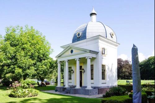 a white building with a dome on top at Historical house on river Vecht in Maarssen