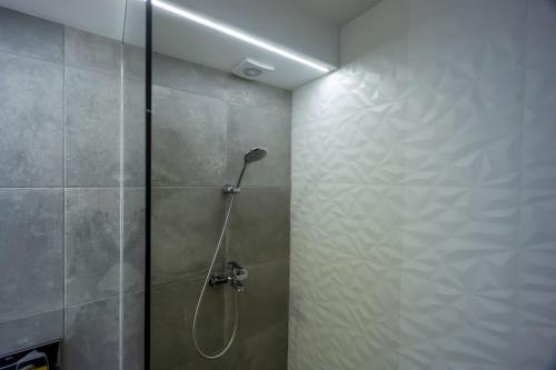 a shower with a shower head in a bathroom at Uptown Elegant Apartment in Voluntari