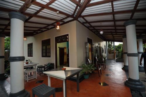 a large room with columns and tables and chairs at Serene villa in Galle