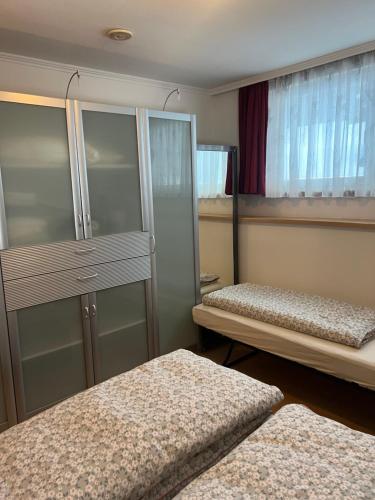 een slaapkamer met 2 bedden, een kast en ramen bij Ortners Ferienwohung in Bischofshofen