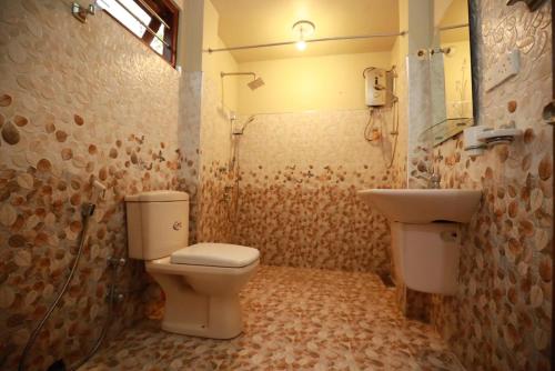 a bathroom with a toilet and a sink at Serene villa in Galle