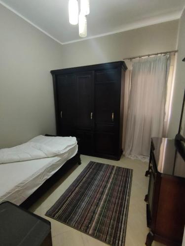 a bedroom with a bed and a dresser and a rug at Luxury Host -219- Dream Land in 6th Of October
