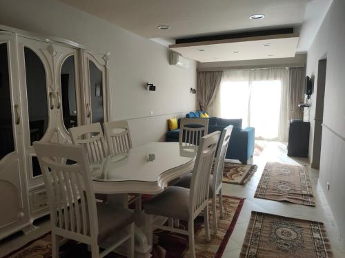 a dining room with a table and chairs and a couch at Luxury Host -219- Dream Land in 6th Of October