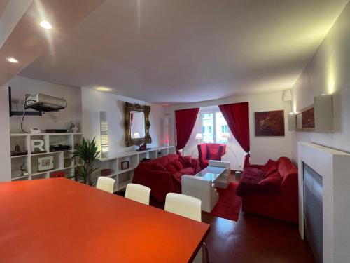 uma sala de estar com mobiliário vermelho e uma mesa vermelha em Red Flat Paris em Paris