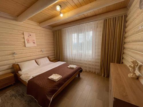 1 dormitorio con 1 cama en una habitación de madera en Horizon Apartmens, en Yablunytsya