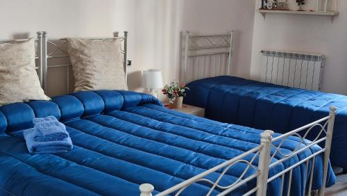 a large blue bed in a room with two beds at Alba Ionica Taranto in Taranto