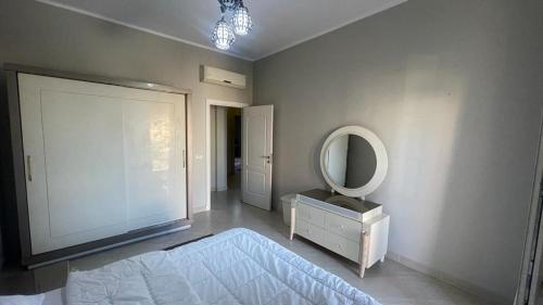 a bedroom with a large mirror and a dresser and a television at Luxury Host -219- Dream Land in 6th Of October