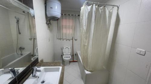 a bathroom with a sink and a toilet and a shower at Luxury Host -219- Dream Land in 6th Of October