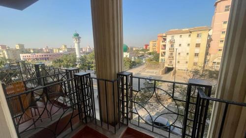 a balcony with a view of a city with a clock tower at Luxury Host -219- Dream Land in 6th Of October
