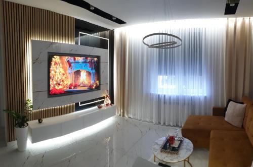 a living room with a flat screen tv on a wall at VIP Room 2+2 in Konin