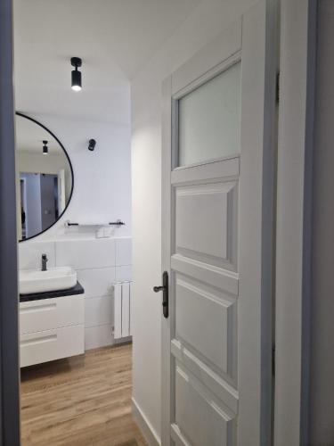 a bathroom with a white door and a sink at Willa Kora in Szczyrk
