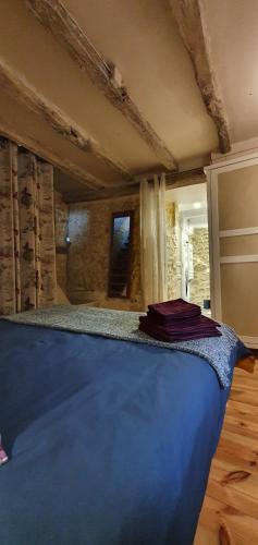 - une chambre avec un lit bleu dans l'établissement La Marguerite, à Brossac