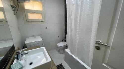 a white bathroom with a sink and a toilet at Luxury Host -219- Dream Land in 6th Of October