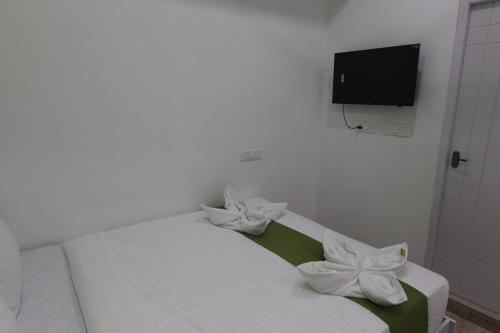 a white bed with white flowers on top of it at Athulya Stays in Bengaluru