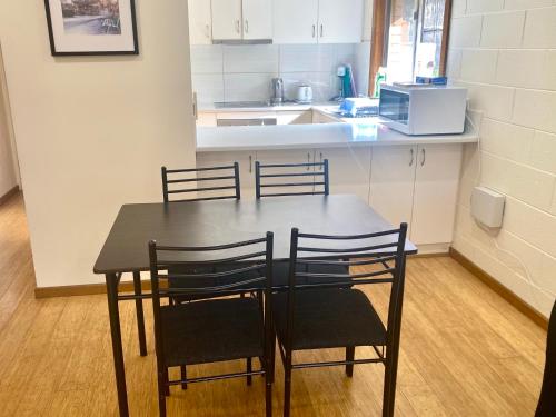een eettafel met vier stoelen in een keuken bij Cozy Hobart Garden Retreat in Sandy Bay