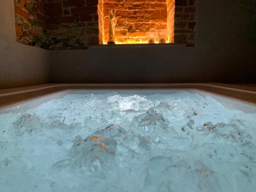 a bath tub filled with snow in front of a fireplace at B&B Villa Antilia in Busca