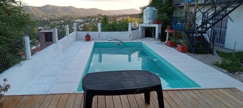 a small pool with a black stool in front of it at El Chañar in Villa Carlos Paz