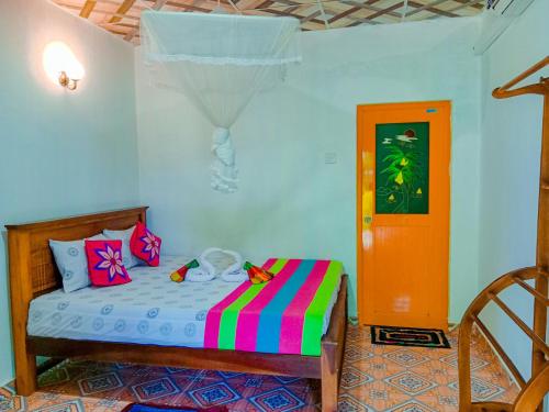 a bedroom with a bed with a colorful blanket at Chanaka Holiday Inn in Sigiriya