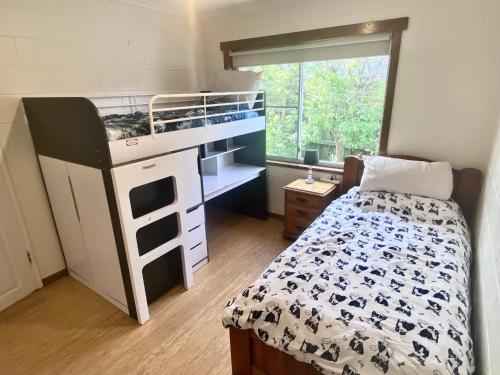 een kleine slaapkamer met een stapelbed en 2 aparte bedden bij Cozy Hobart Garden Retreat in Sandy Bay