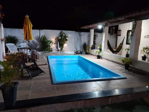a swimming pool in the middle of a patio at Rochedo Casa de Praia in Nova Viçosa