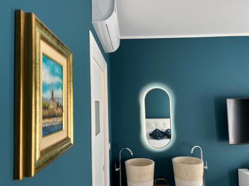 a room with blue walls and a mirror and stools at Casa Del Caval Bianco in Venaria Reale
