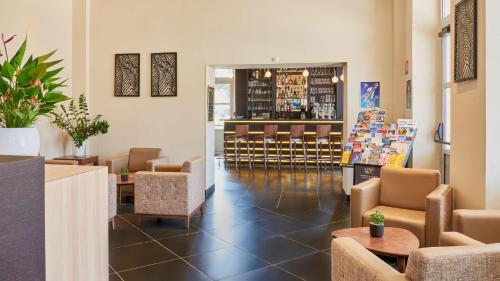 a lobby with chairs and a bar in the background at Résidence Château du Mée in Le Mée-sur-Seine