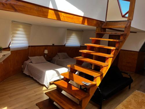 a bedroom with a loft bed and a staircase with a bed at Domos chucauco in Villarrica