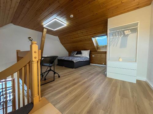 1 dormitorio con 1 cama y escritorio en una habitación en Galeriewohnung in Menzenschwand, en Menzenschwand-Hinterdorf