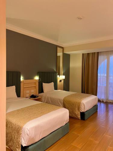 a hotel room with two beds and a window at Xanadu Makadi Bay - High Class All Inclusive in Hurghada