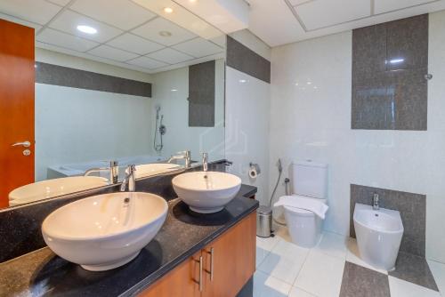 a bathroom with two sinks and a toilet at Difc 1 Bd apartment in Park Tower in Dubai