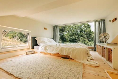 a bedroom with a bed and a large window at Tinyhouse Minimalus Panorama Schlafloft im Grünen in Dessighofen