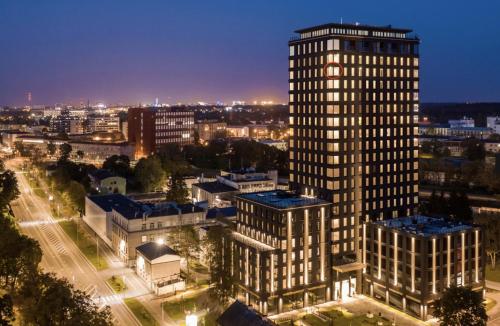 a tall building in a city at night at Luxury sea view studio apartment in a skyscraper! in Tallinn