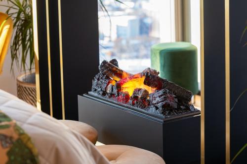 a fire pit in a room next to a window at Luxury sea view studio apartment in a skyscraper! in Tallinn